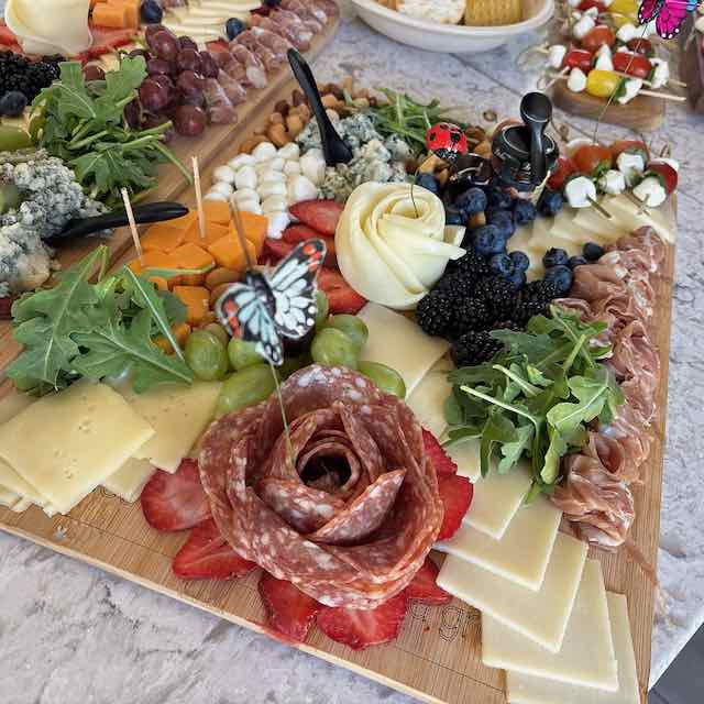 An abundant charcuterie board with a salami rosette