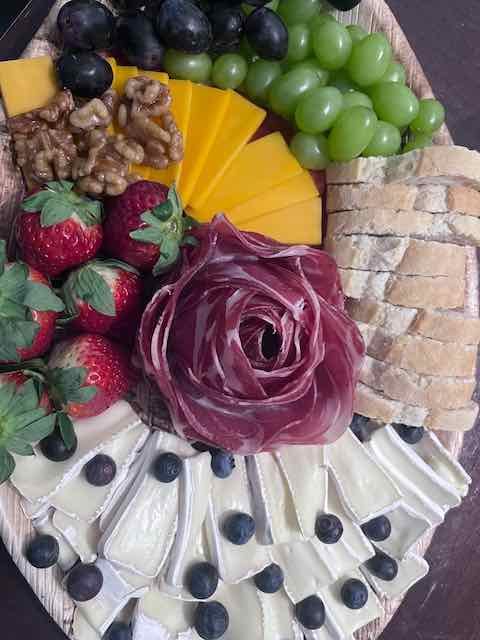 A floral fruit and cheese arrangement