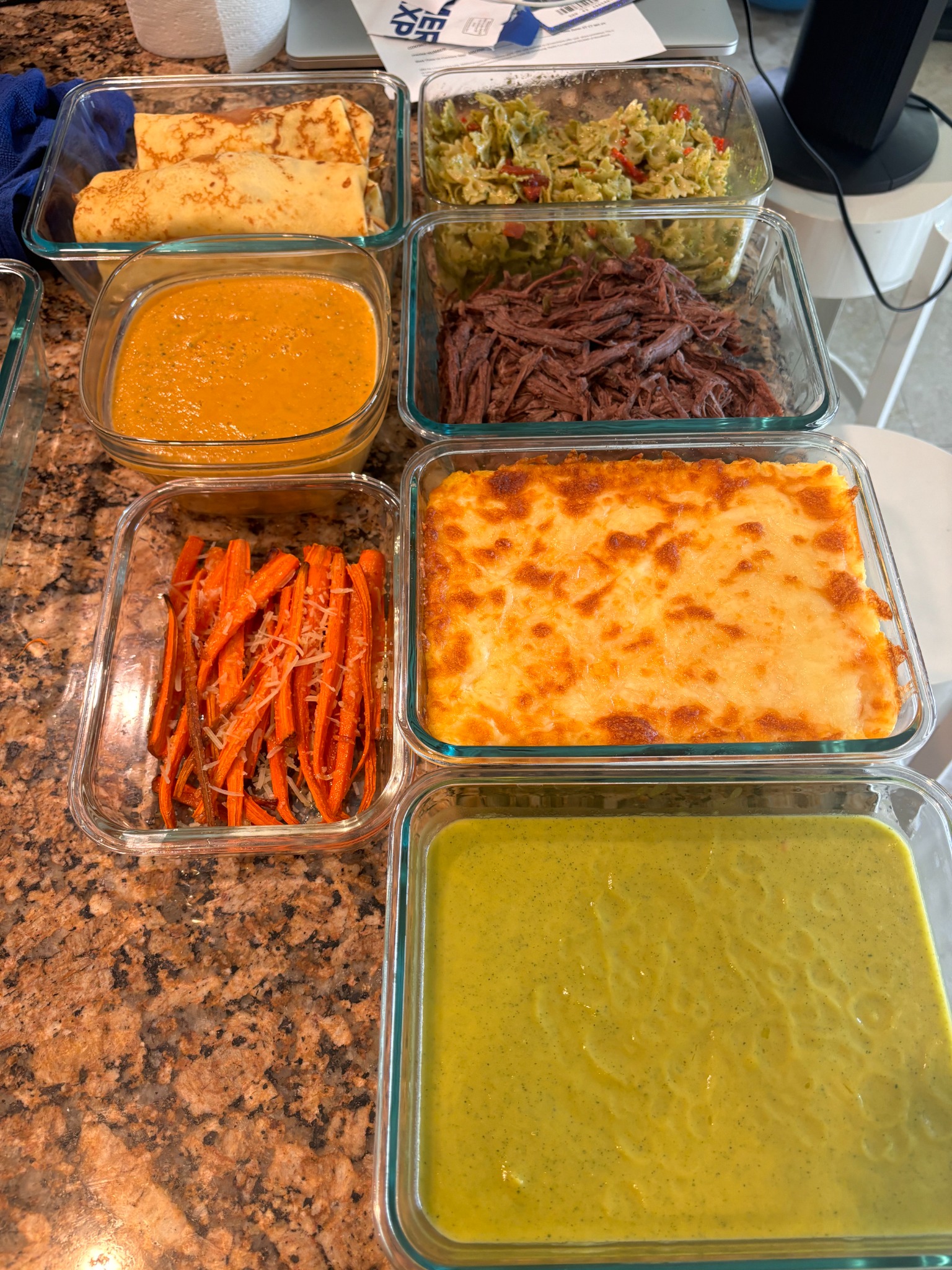 Colorful cooked vegetables, sauces, and entrées packaged for meal prep