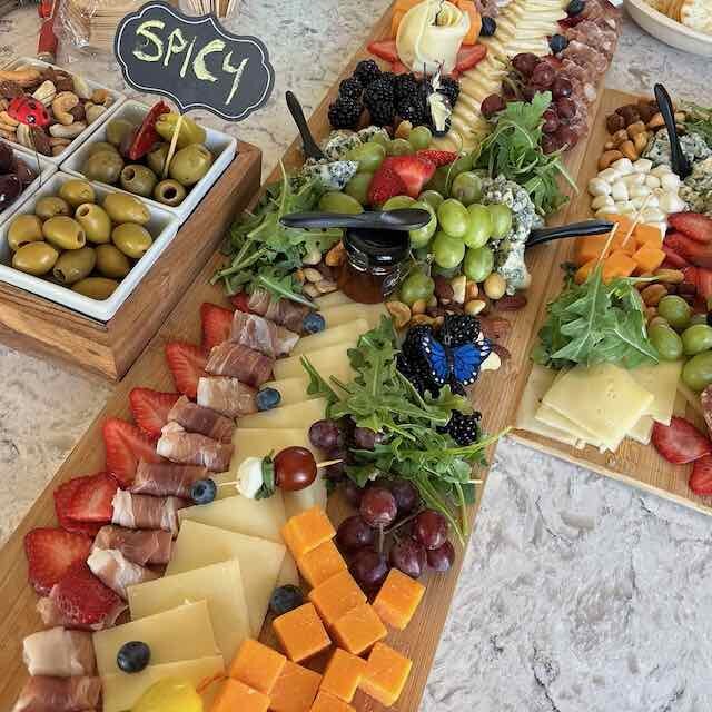 A full Delicidad grazing table with cheeses, fruit, meats, and olives